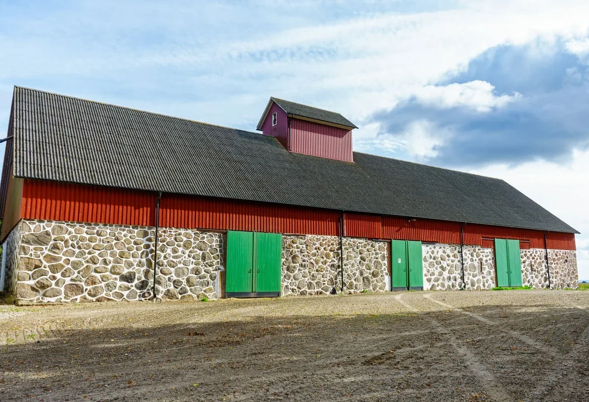 Façade d'une grande grange rurale en pierre et bois
