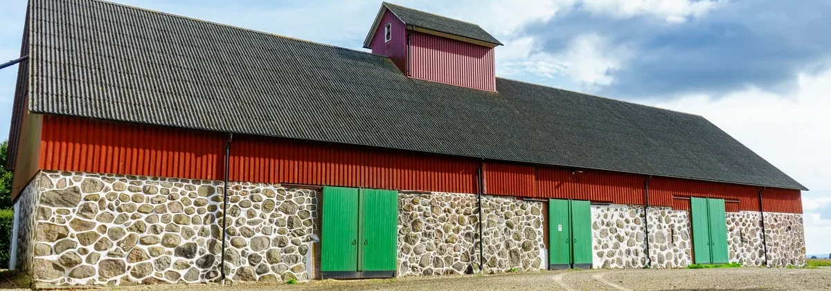 Façade d'une grande grange rurale en pierre et bois