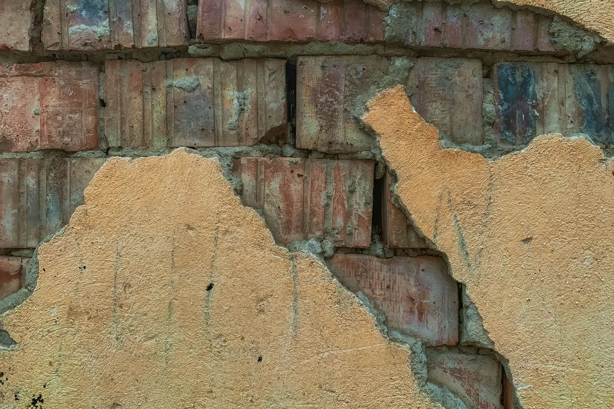 Enduit ancien dégradé révélant la maçonnerie